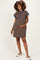 woman wearing a brown and navy striped maternity polo dress and showcasing her baby bump