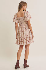 woman wearing a floral smocked sundress with puff sleeves and a tiered skirt, shown from the back