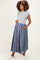 woman wearing a gray short sleeve top and a blue plaid maternity maxi skirt, showing her baby bump