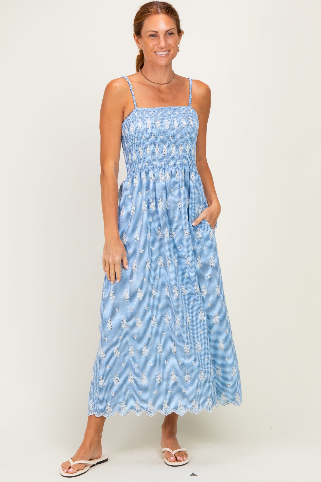 woman wearing a blue patterned maxi dress with spaghetti straps and pockets