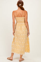 woman wearing a yellow floral smocked back maxi dress with adjustable straps and a flowy silhouette