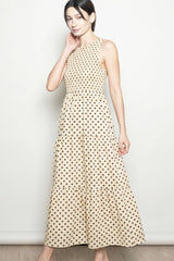 woman wearing a beige polka dot maxi dress with a fitted bodice and tiered skirt