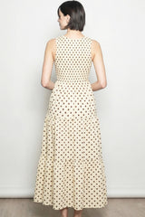 woman wearing a back view of a beige midi dress with a polka dot pattern and a tiered skirt