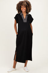 woman wearing a black maternity maxi dress with a striped collar and side slits, smiling and showing her baby bump
