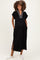 woman wearing a black maternity maxi dress with a striped collar and side slits, smiling and showing her baby bump
