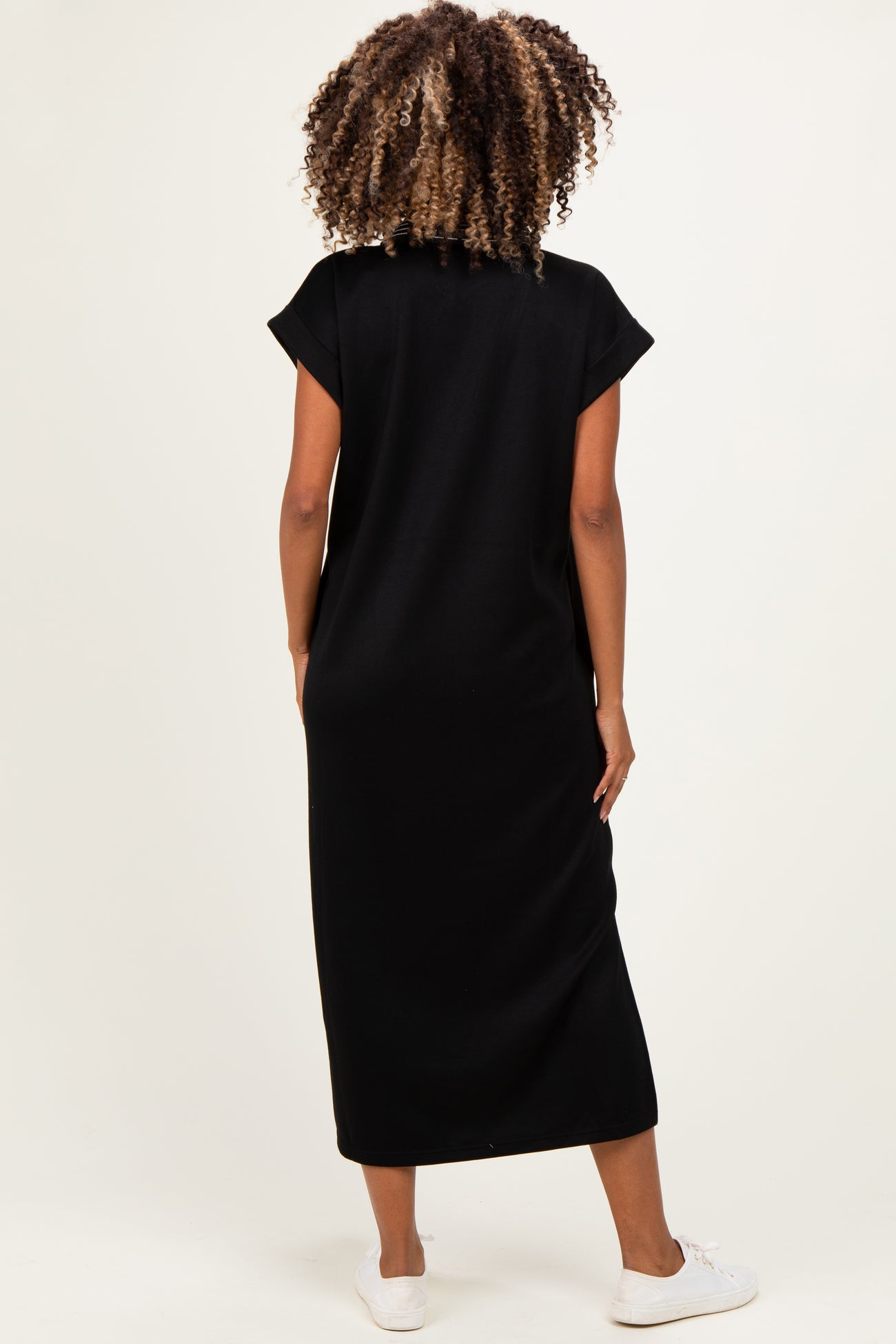 woman wearing a black maternity maxi dress with short sleeves and a relaxed fit, showing a baby bump from the back