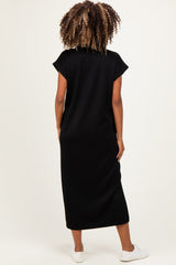 woman wearing a black maternity maxi dress with short sleeves and a relaxed fit, showing a baby bump from the back