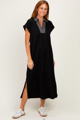 woman wearing a black cap sleeve midi dress with a striped collar and side slits