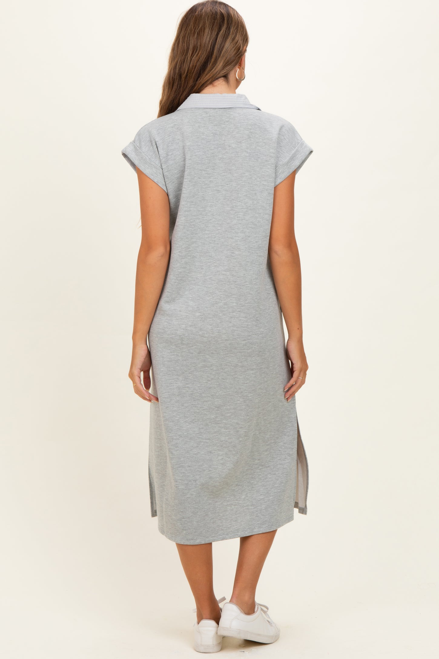 woman wearing a gray short sleeve maternity dress with side slits and a relaxed fit, viewed from the back