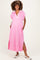 woman wearing a pink maternity maxi dress with a collar and side pockets, featuring a relaxed fit and slits at the sides