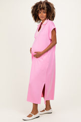 woman wearing a pink maternity dress with short sleeves and side slits, holding her baby bump