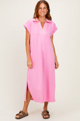 woman wearing a hot pink short sleeve midi dress with a collar and side slits