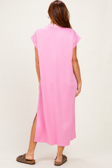 woman wearing a pink short sleeve maxi dress with side slits, standing with her back to the camera