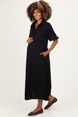 woman wearing a black button-up maternity dress with short sleeves and pockets, highlighting her baby bump