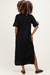woman wearing a black maternity maxi dress with short sleeves and side slits, showing a relaxed fit