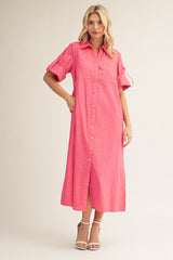 woman wearing a bright pink button-up midi dress with short sleeves and a front slit