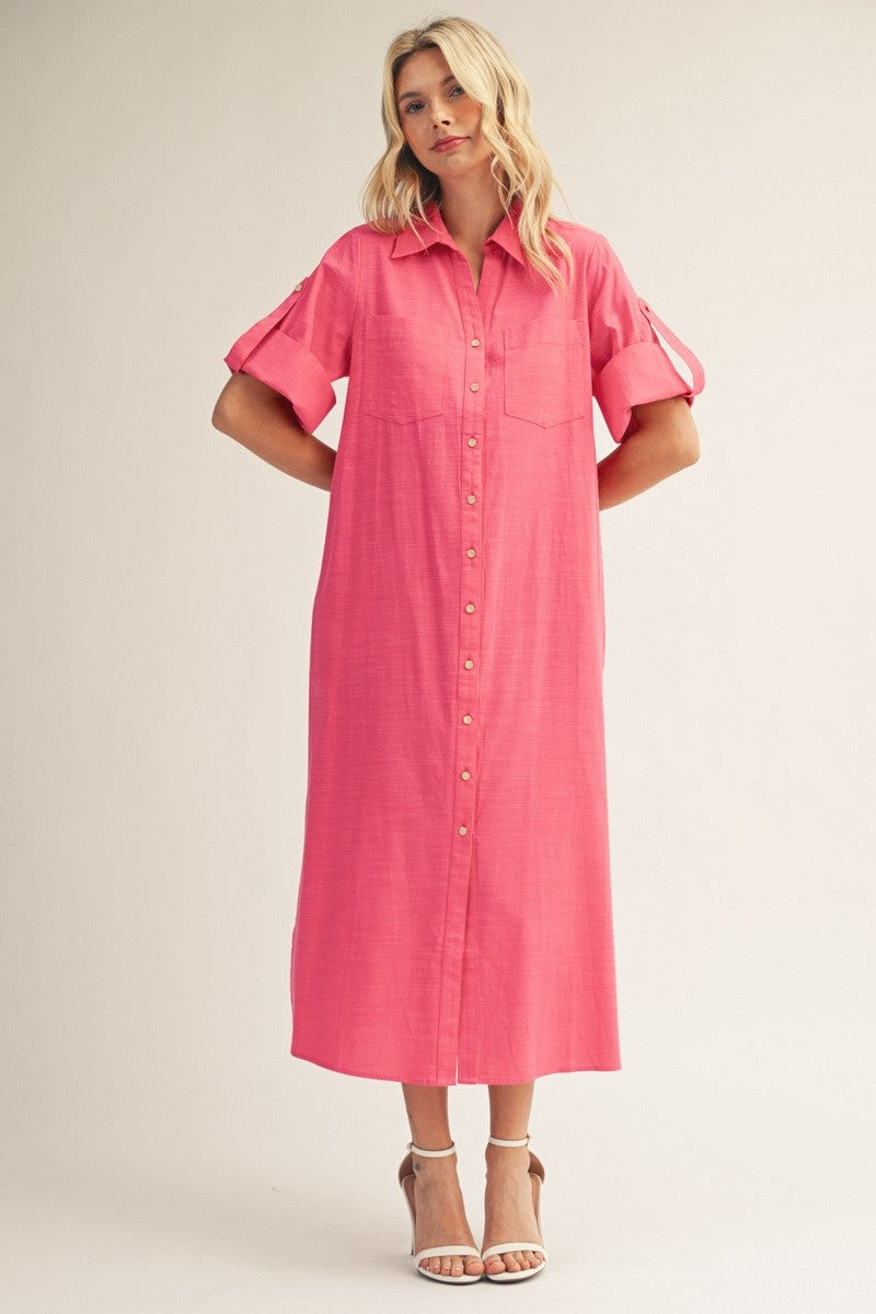 woman wearing a bright pink midi shirt dress with button-down front and rolled short sleeves