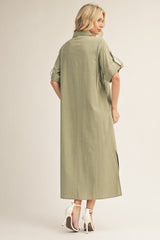 woman wearing an olive green maxi shirt dress with rolled sleeves and side slits, shown from the back with high heels