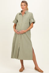 woman wearing an olive green button-up maternity dress with rolled sleeves and side slits, holding her baby bump