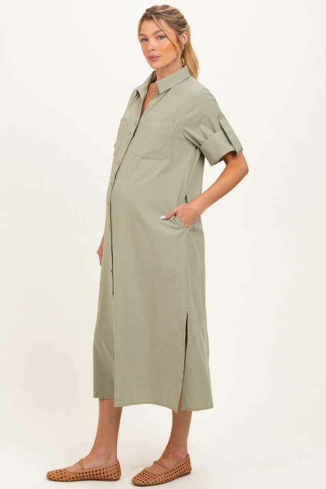 woman wearing a light olive green short sleeve maternity dress with front pockets and side slits, showing her baby bump