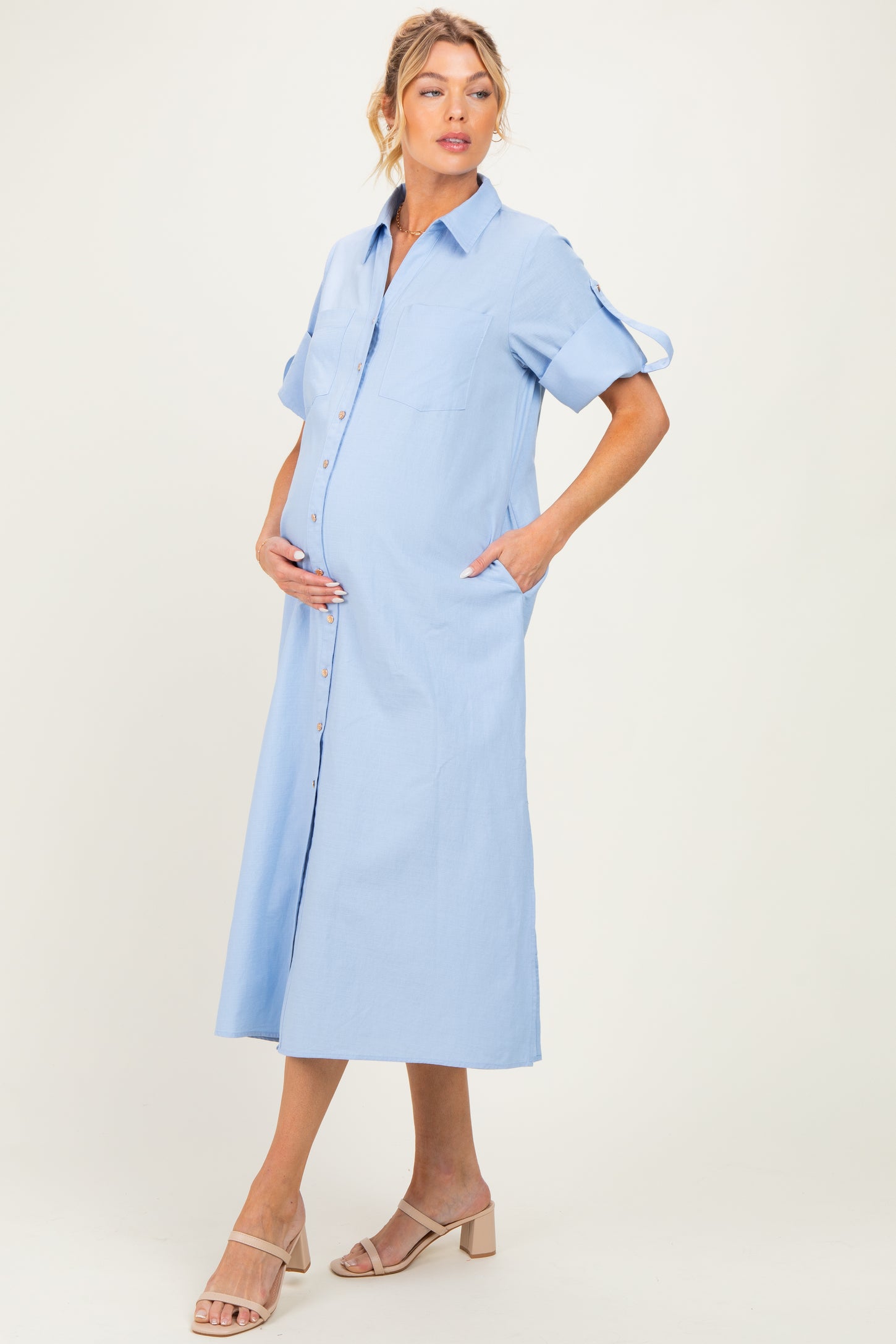 woman wearing a light blue maternity shirt dress with pockets and a visible baby bump