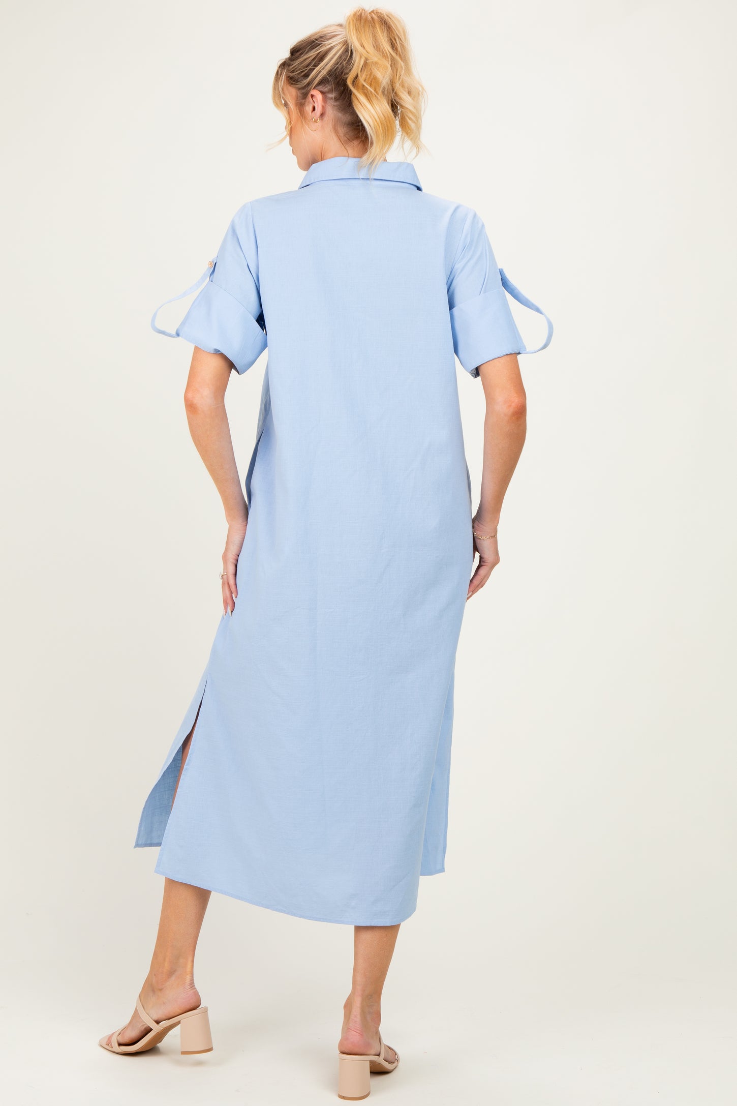 woman wearing a light blue maternity maxi dress with short sleeves and side slits, showing her back