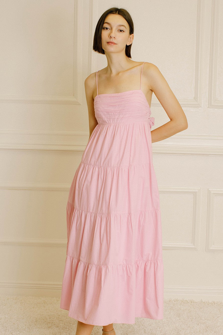 woman wearing a pink tiered maxi dress with spaghetti straps and a smocked bodice