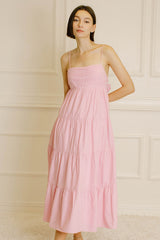 woman wearing a pink tiered maxi dress with spaghetti straps and a smocked bodice