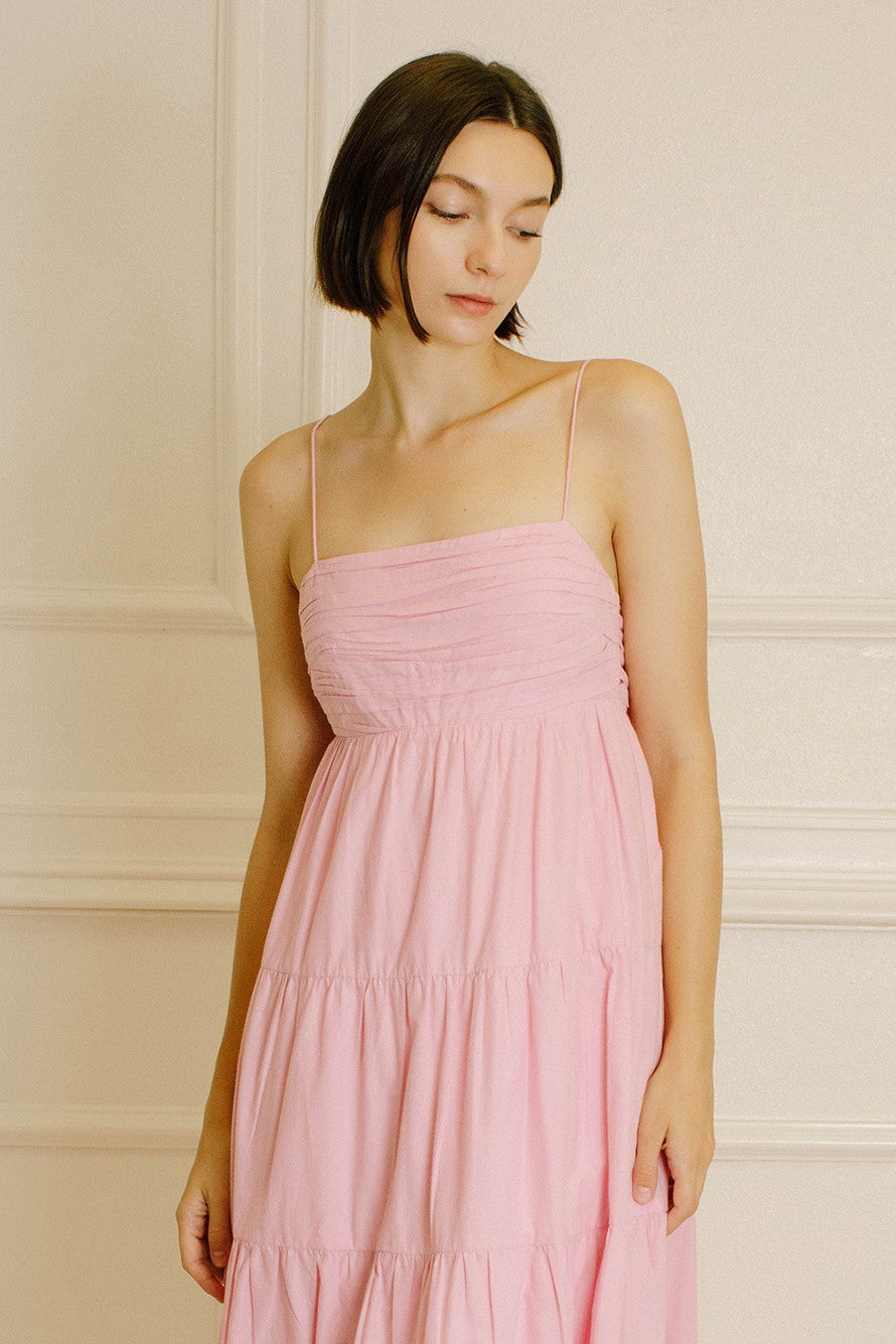 woman wearing a pink spaghetti strap tiered maxi dress with a ruched bodice
