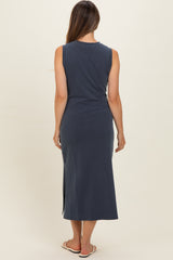 woman wearing a navy blue sleeveless maxi dress with side slits, designed for maternity wear