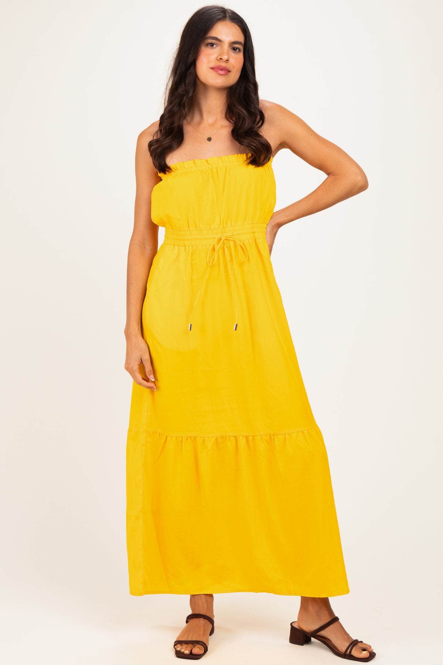 woman wearing a yellow strapless maxi dress with an elastic waist and ruffle hem