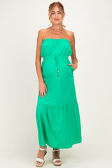 woman wearing a vibrant green strapless maternity maxi dress with an elastic waist and pockets