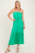 woman wearing a green strapless maxi dress with an elastic waistband and tiered skirt, standing in a neutral background