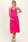 woman wearing a bright pink halter maternity dress with a flowing skirt and holding her baby bump