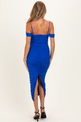 woman wearing a blue ruched maternity dress with off-the-shoulder sleeves and a slit at the back