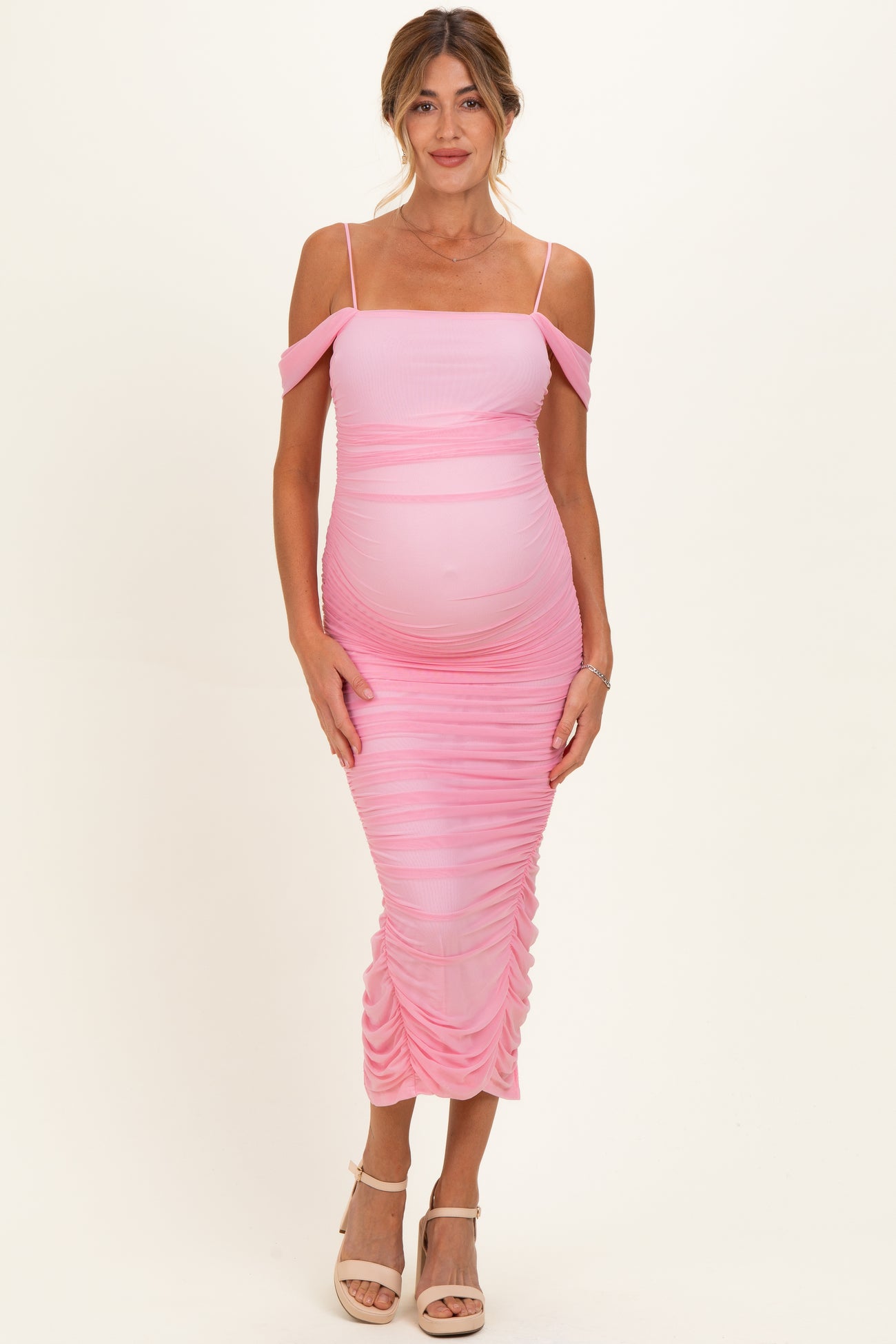 woman wearing a pink off-shoulder ruched maternity dress with a visible baby bump