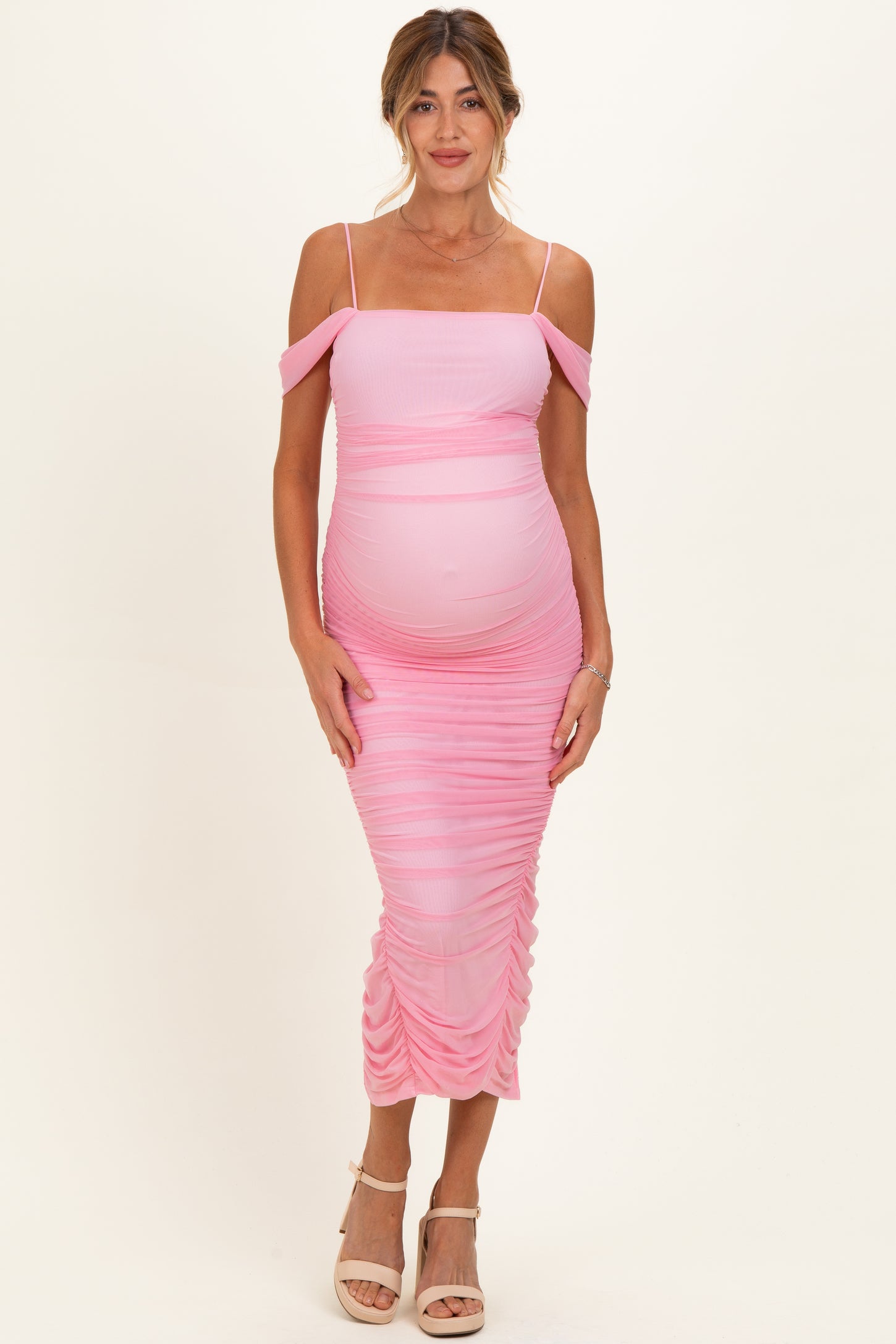 woman wearing a pink off-shoulder ruched maternity dress with a visible baby bump