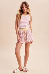 woman wearing a striped pink and white tank top and matching shorts with a yellow drawstring waistband