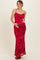 woman wearing a red floral maternity gown with a cowl neckline and spaghetti straps, holding her baby bump