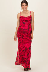 woman wearing a red floral print maternity dress with spaghetti straps and a fitted silhouette, showcasing her baby bump