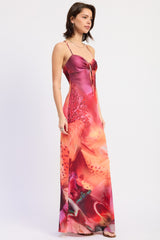 woman wearing a pink and orange floral maxi dress with thin straps and a front tie detail