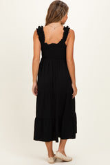 woman wearing a black maternity maxi dress with ruffle straps and tiered skirt, showing a smooth back view