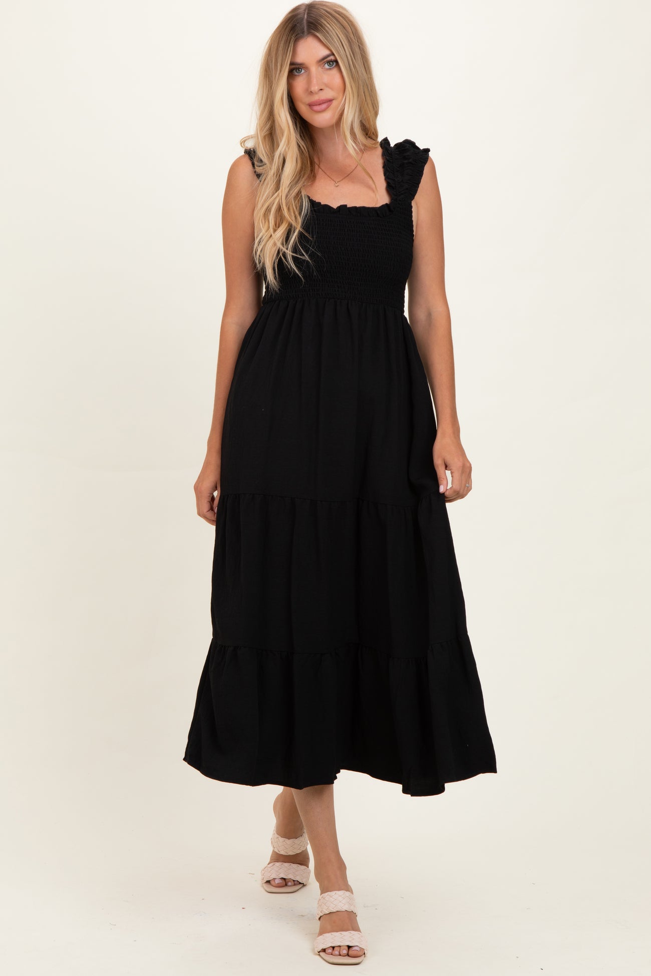 woman wearing a black tiered maxi dress with ruffle straps and a smocked bodice
