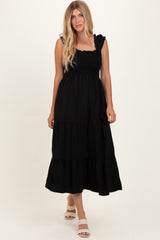 woman wearing a black tiered maxi dress with ruffle straps and a smocked bodice