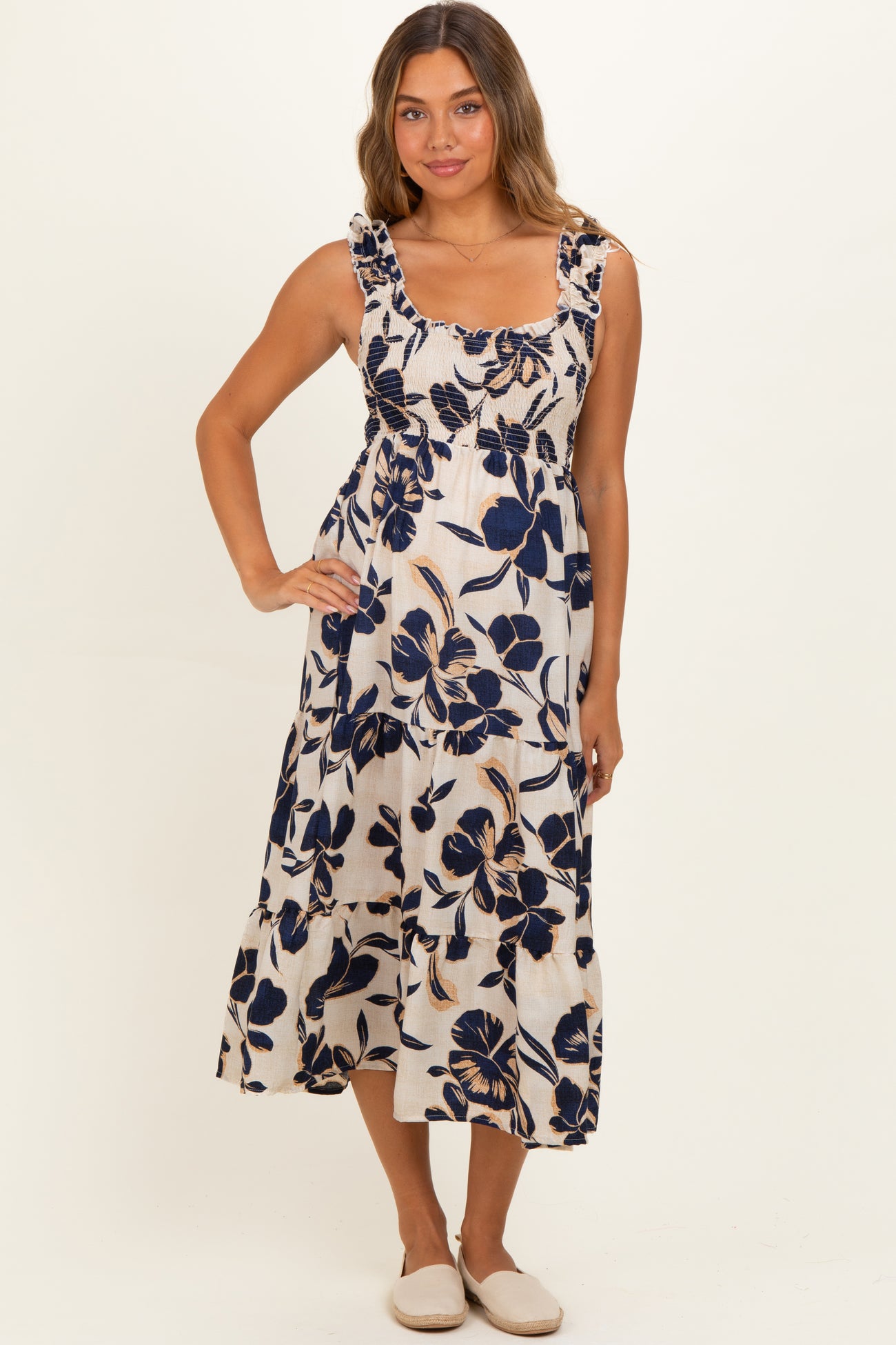 woman wearing a floral print maternity dress with tiered skirt and ruffled straps, casual summer style