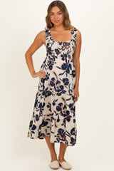 woman wearing a floral print maternity dress with tiered skirt and ruffled straps, casual summer style