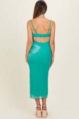 woman wearing a teal maternity dress with a back cutout and a fitted silhouette