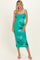 woman wearing a green floral midi dress with adjustable spaghetti straps and a fitted silhouette