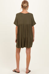woman wearing an olive green maternity dress with a loose fit and short sleeves, back view, showing a flowing silhouette