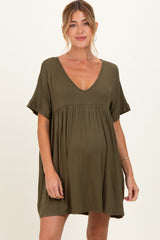 woman wearing an olive green maternity dress with a deep v-neck and short sleeves, showing her baby bump